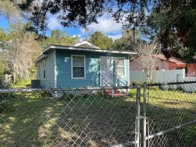 bungalow-style home with a front lawn and central air condition unit