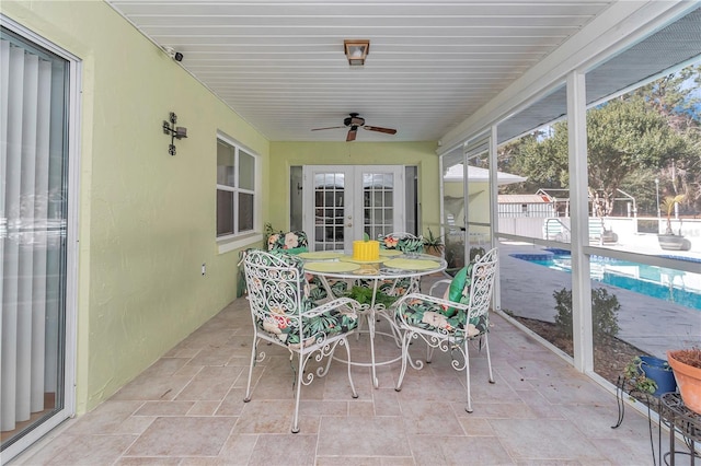 sunroom / solarium featuring ceiling fan and french doors