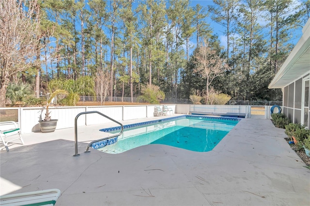 view of swimming pool featuring a patio and a sunroom