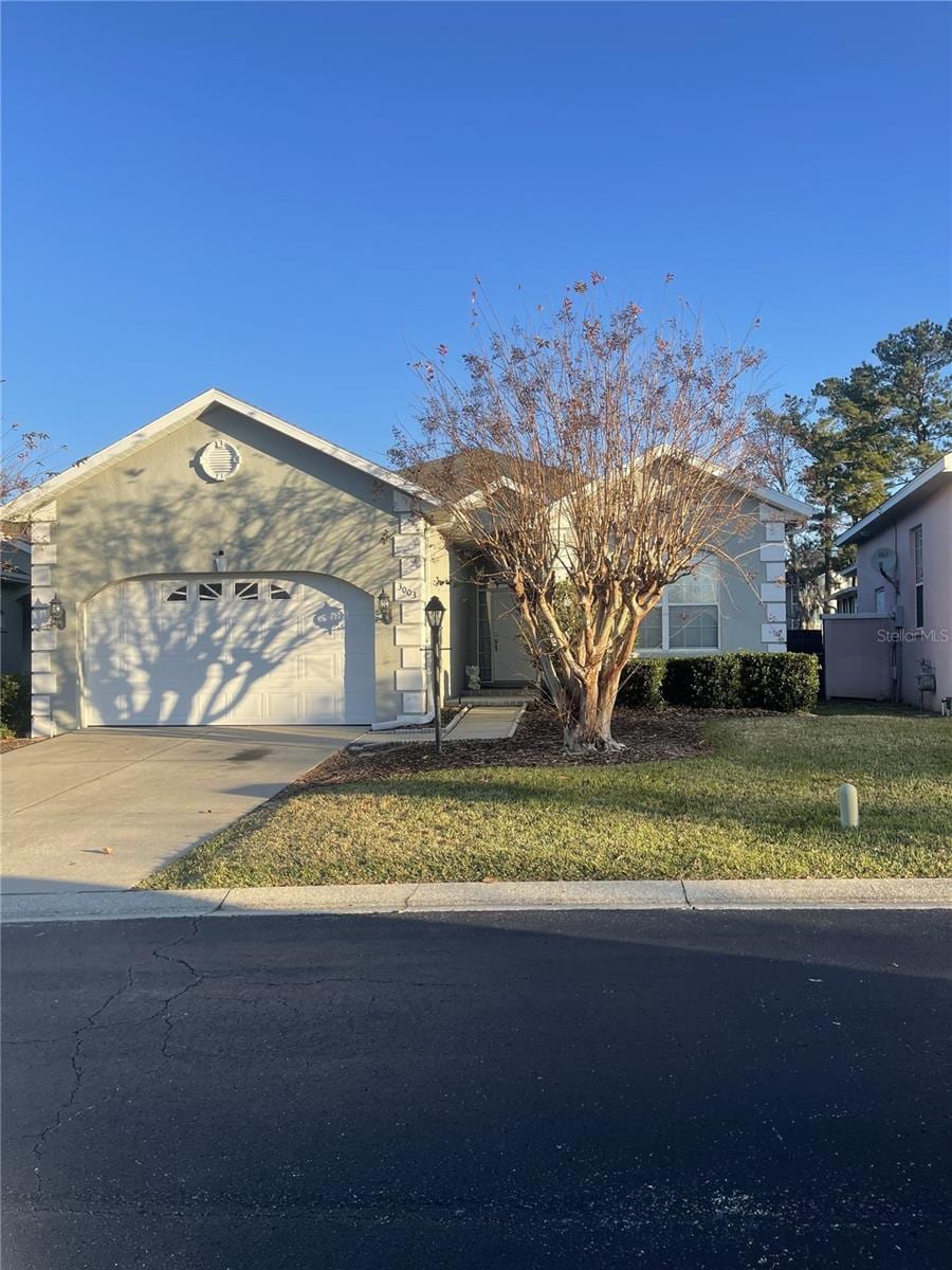 view of front of home with a front yard and a garage