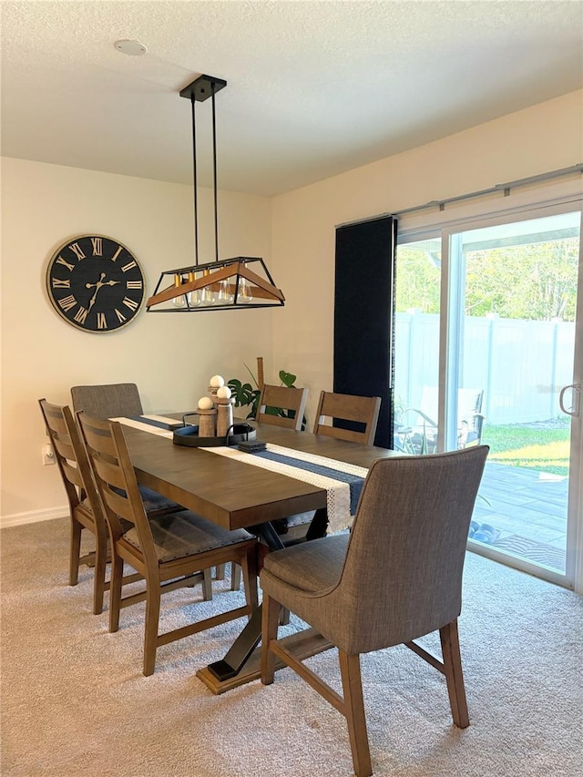 dining room featuring light colored carpet and a textured ceiling