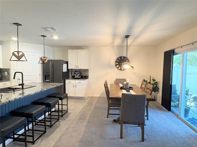 tiled dining room with sink and a textured ceiling