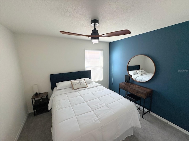 carpeted bedroom featuring a textured ceiling and ceiling fan