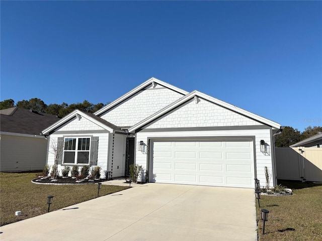 view of front of house featuring a front yard, an attached garage, driveway, and fence