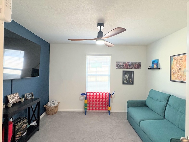 living area with ceiling fan, a textured ceiling, and carpet flooring