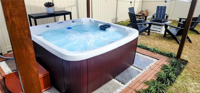 exterior space featuring a hot tub and a fire pit