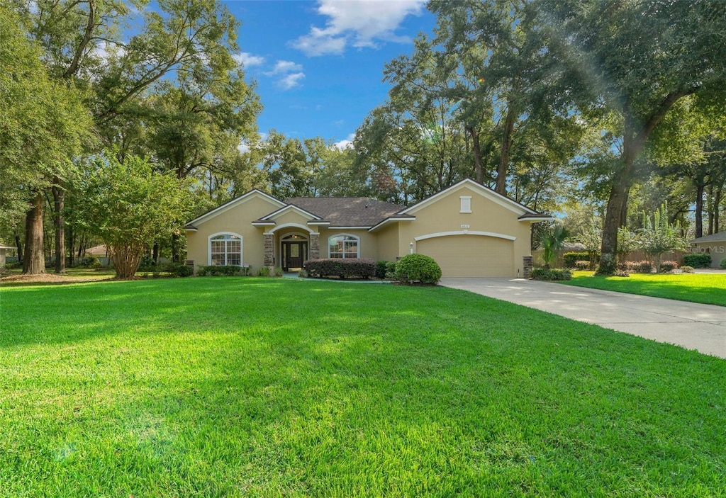 single story home with a garage and a front yard