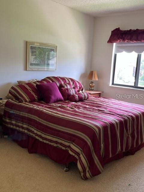 bedroom featuring a textured ceiling and carpet floors