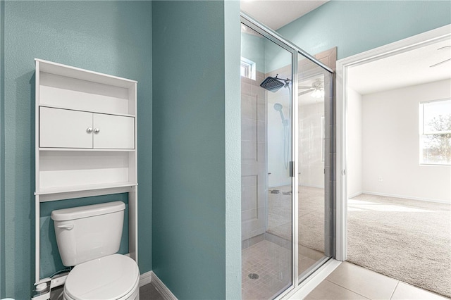 bathroom featuring tile patterned floors, a shower with shower door, and toilet