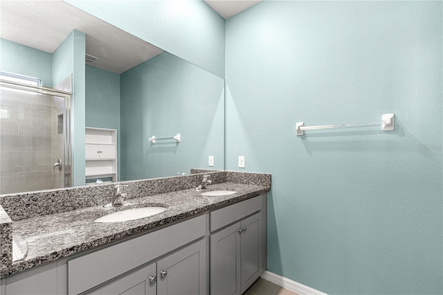 bathroom with tile patterned flooring, vanity, and walk in shower