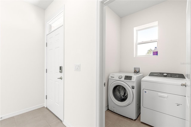 clothes washing area featuring light tile patterned floors and washing machine and dryer