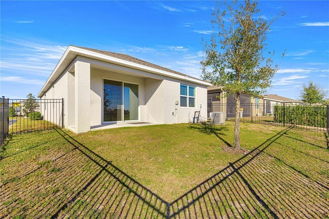 rear view of property with a yard and central AC