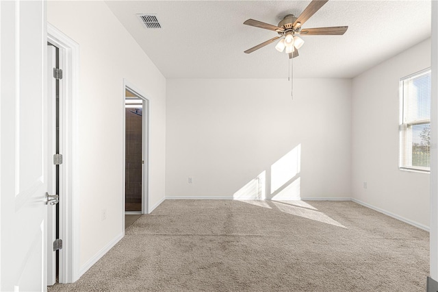 carpeted spare room featuring a textured ceiling and ceiling fan