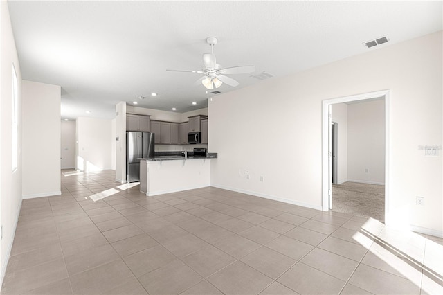 unfurnished living room with ceiling fan and light tile patterned flooring