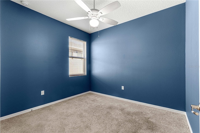 carpeted empty room featuring ceiling fan and a textured ceiling