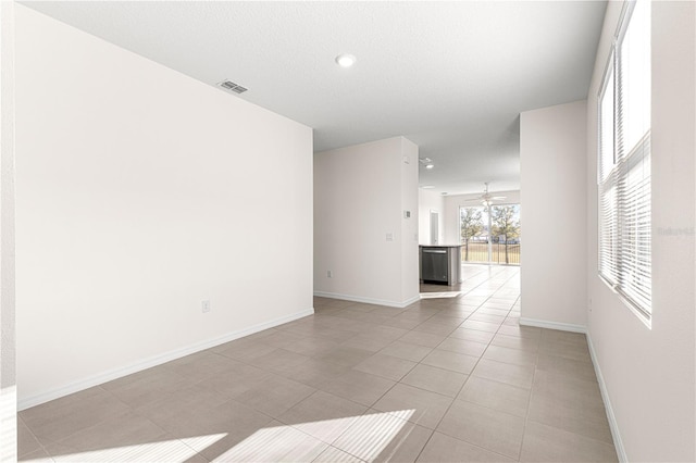 tiled spare room featuring ceiling fan