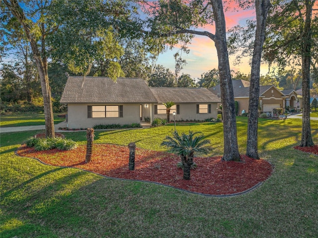 ranch-style home featuring a lawn