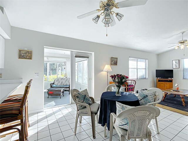 dining area featuring light tile patterned floors, vaulted ceiling, and ceiling fan