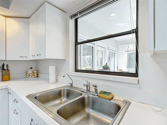 kitchen featuring white cabinetry and sink