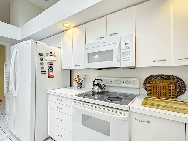 kitchen with light tile patterned floors, white appliances, and white cabinetry