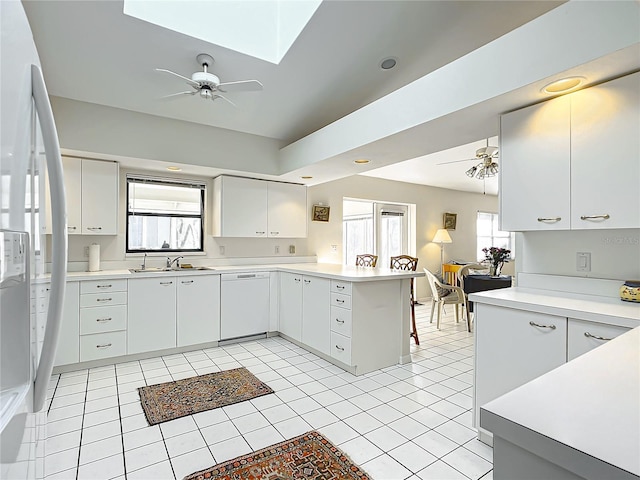 kitchen with kitchen peninsula, white cabinets, and white appliances