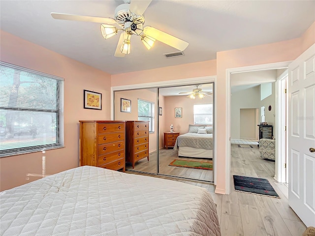 bedroom featuring multiple windows, a closet, ceiling fan, and light hardwood / wood-style floors