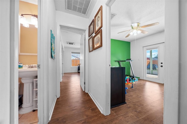 hallway with dark hardwood / wood-style floors and a textured ceiling