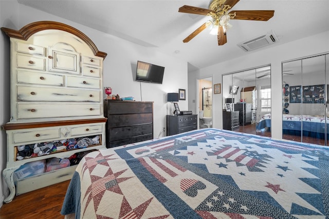 bedroom featuring multiple closets, ceiling fan, and dark hardwood / wood-style floors