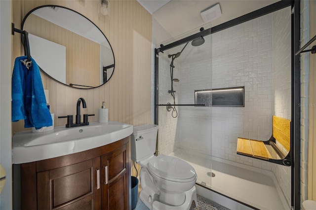 bathroom with vanity, toilet, and a shower with shower door