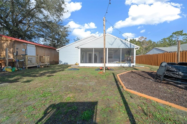 rear view of house with a sunroom and a yard