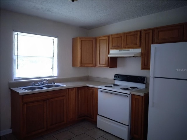 kitchen with a textured ceiling, sink, light tile patterned floors, and white appliances