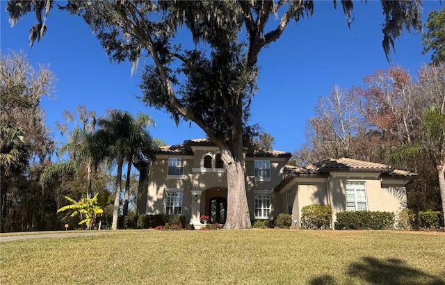 mediterranean / spanish house featuring a front lawn