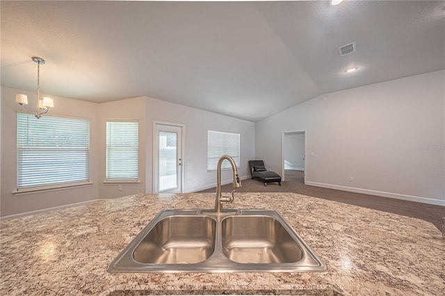 kitchen featuring lofted ceiling, hanging light fixtures, a notable chandelier, and sink