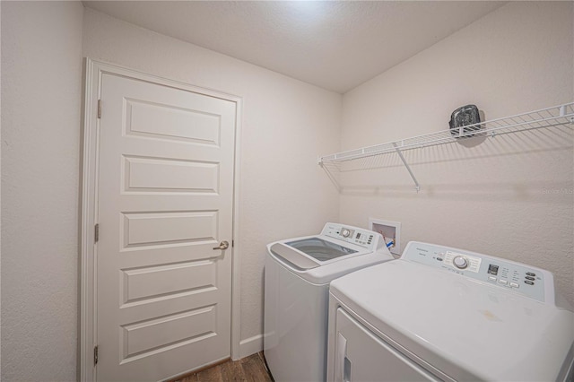 washroom featuring washing machine and dryer and dark wood-type flooring