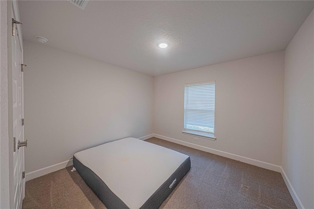 carpeted bedroom featuring a textured ceiling