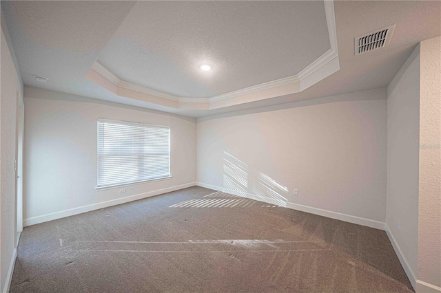 carpeted empty room with a textured ceiling, a raised ceiling, and crown molding