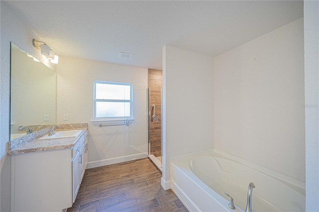 bathroom featuring vanity, hardwood / wood-style flooring, and separate shower and tub