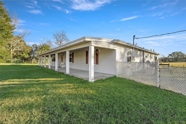 view of side of property with a yard and a patio