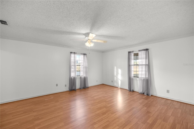 empty room featuring a textured ceiling, light wood-type flooring, ceiling fan, and crown molding