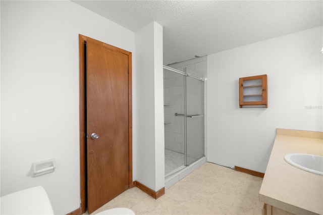 bathroom featuring vanity, a shower with shower door, a textured ceiling, and toilet