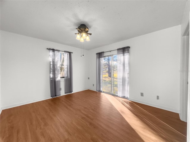 spare room with hardwood / wood-style floors, ceiling fan, a healthy amount of sunlight, and a textured ceiling