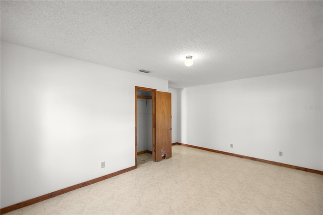 unfurnished room with a textured ceiling