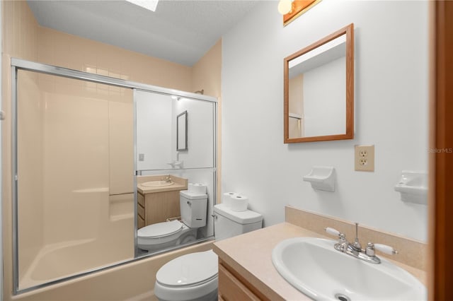 full bathroom featuring toilet, vanity, a textured ceiling, and combined bath / shower with glass door