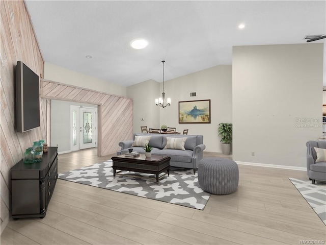 living room with light wood-type flooring, wooden walls, vaulted ceiling, and a notable chandelier