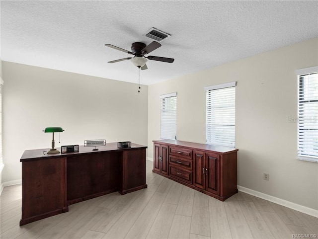 office space featuring ceiling fan, light hardwood / wood-style floors, and a textured ceiling