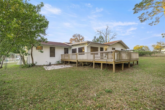 rear view of house with a yard and a wooden deck