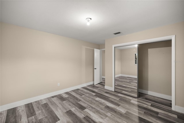 unfurnished bedroom with hardwood / wood-style floors and a closet