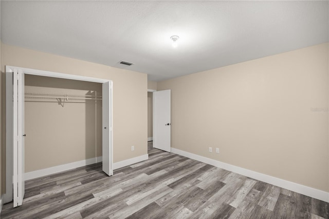 unfurnished bedroom featuring a closet and wood-type flooring