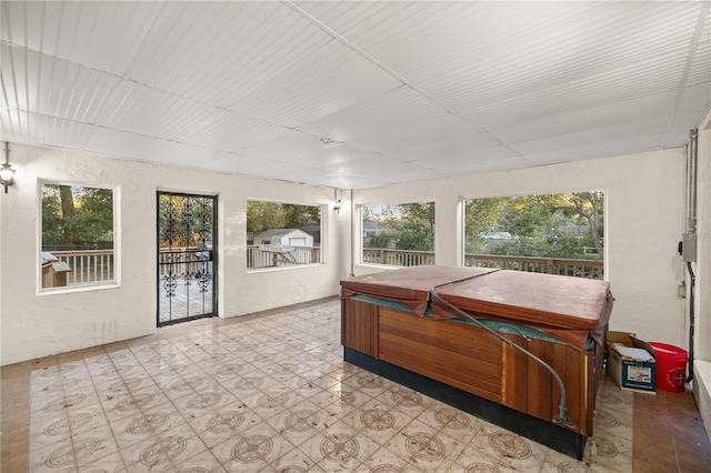 sunroom with a jacuzzi and a drop ceiling