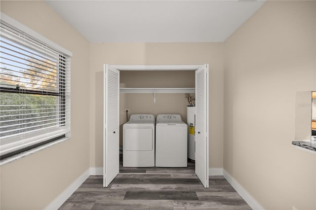 laundry room with washing machine and dryer, dark wood-type flooring, and water heater